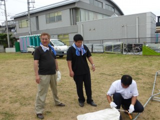 担当委員長L高木に指導するテント張りの達人L宮代